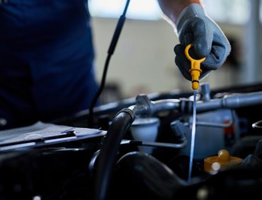 closeup-auto-repairman-checking-car-oil-workshop closeup-auto-repairman-checking-car-oil-workshop